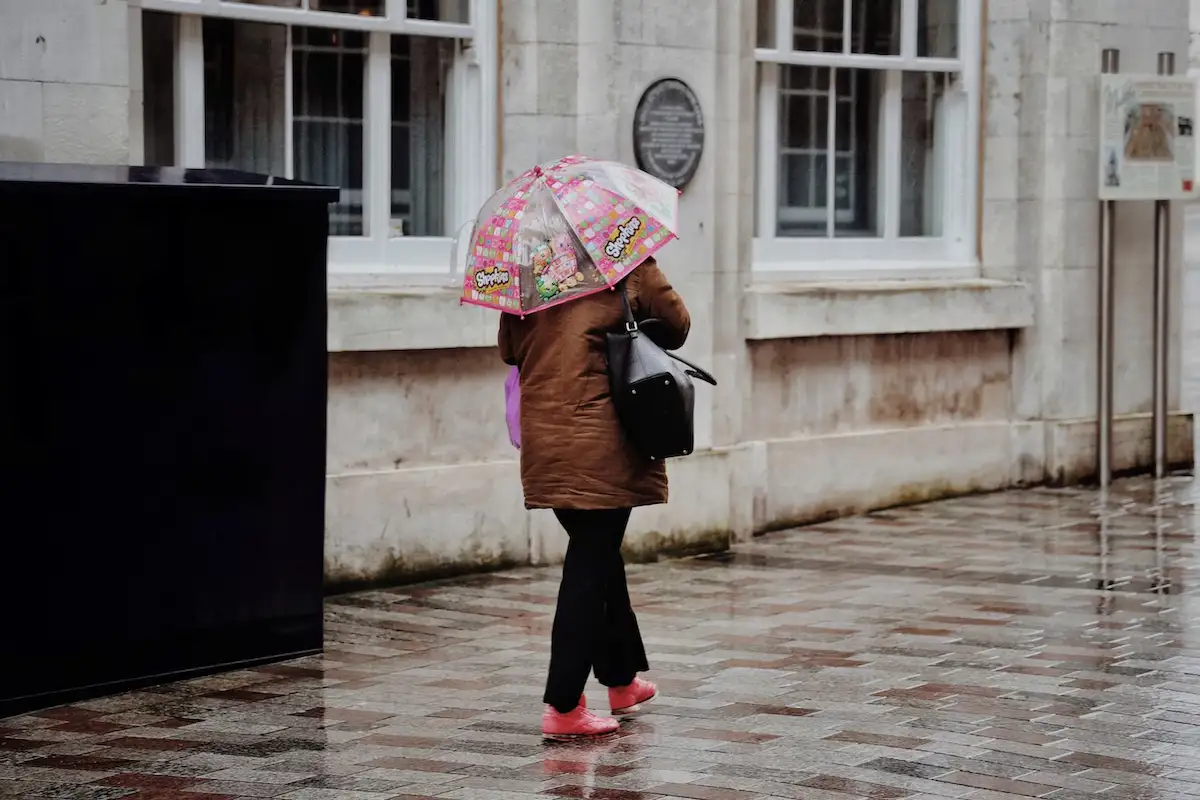 wanita berjalan dengan payung