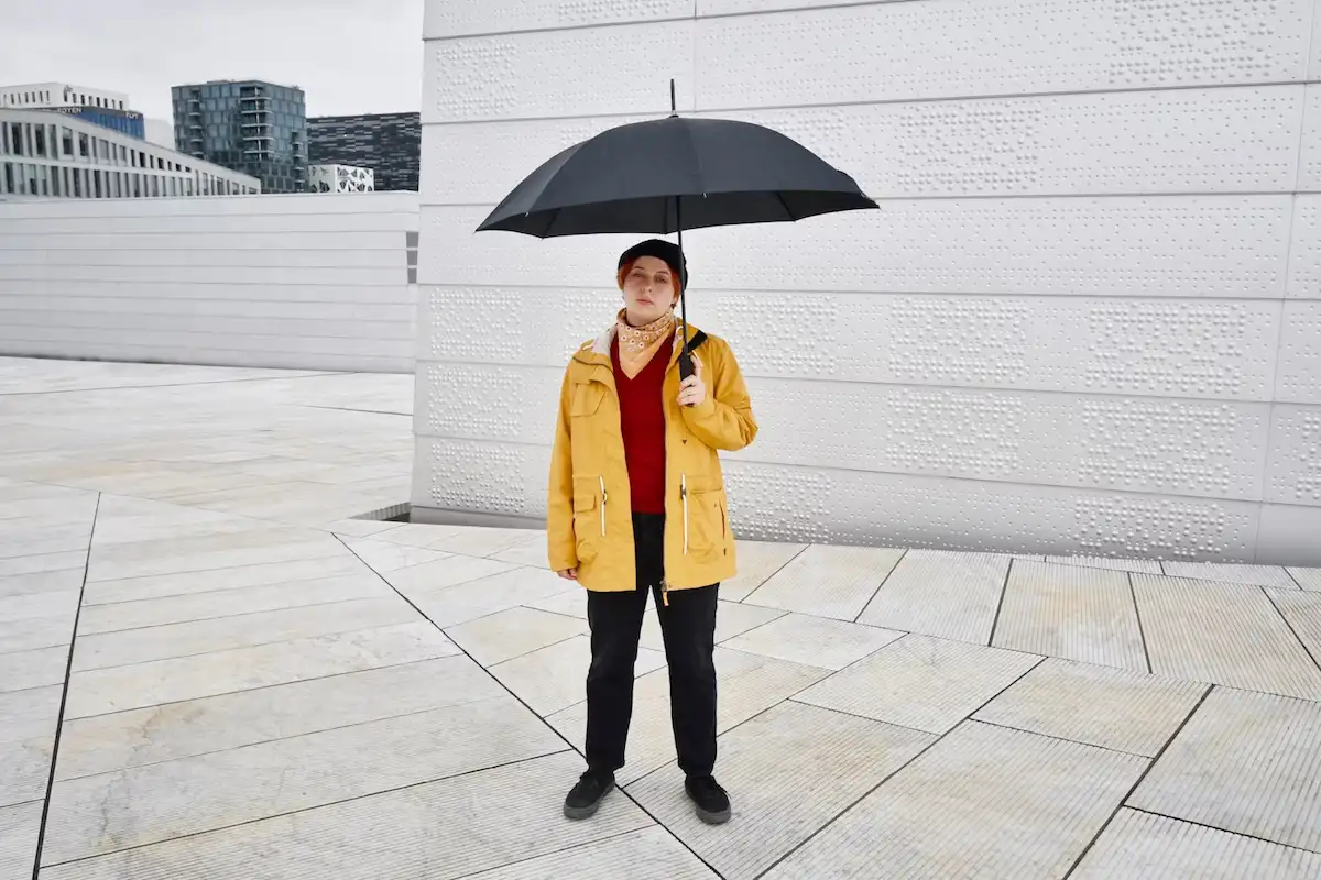wanita dengan payung dan jas hujan