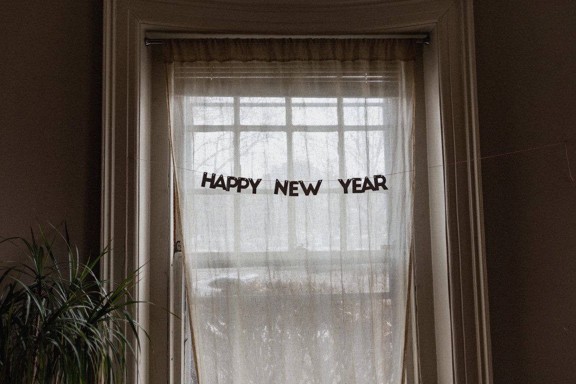 gambar jendela dengan tulisan "happy new year" di tirainya