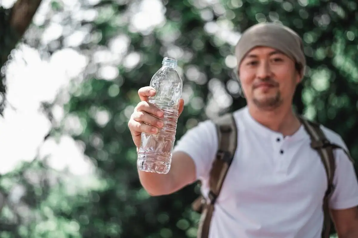 seorang pria memegang botol kemasan air