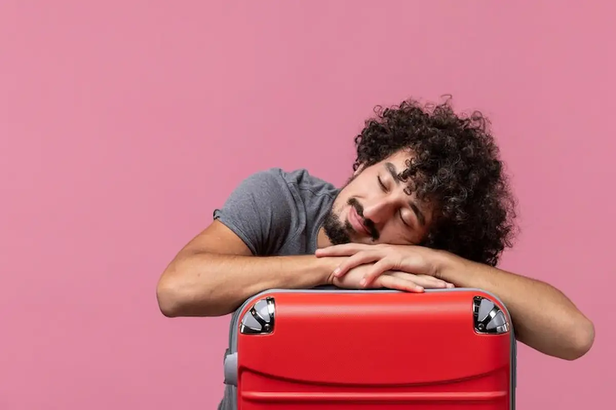 seorang pria tidur di atas koper