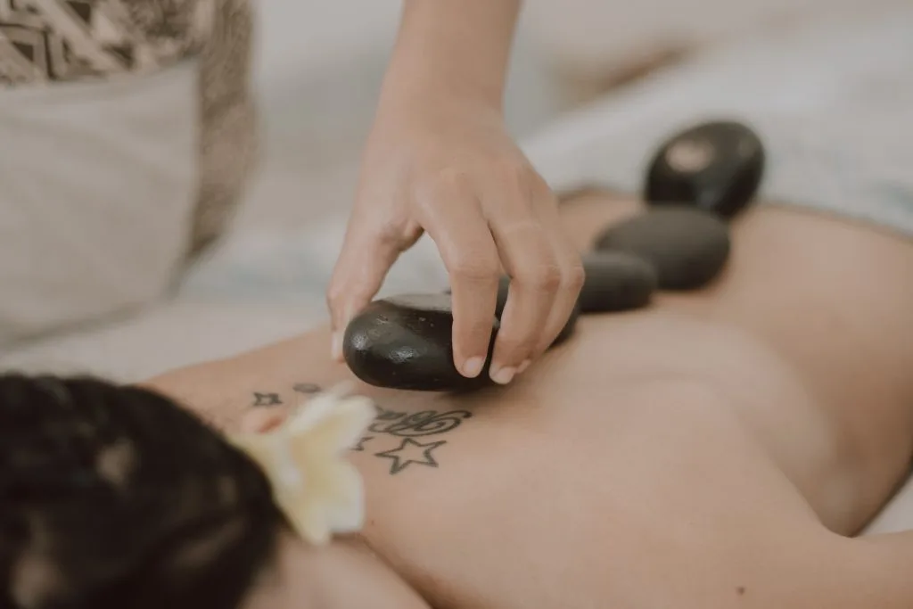 A close-up shot of hot stone massage on someone's back - Best day spa in Ubud