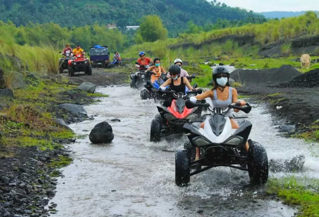 People riding ATV through muddy field - things to do in kintamani