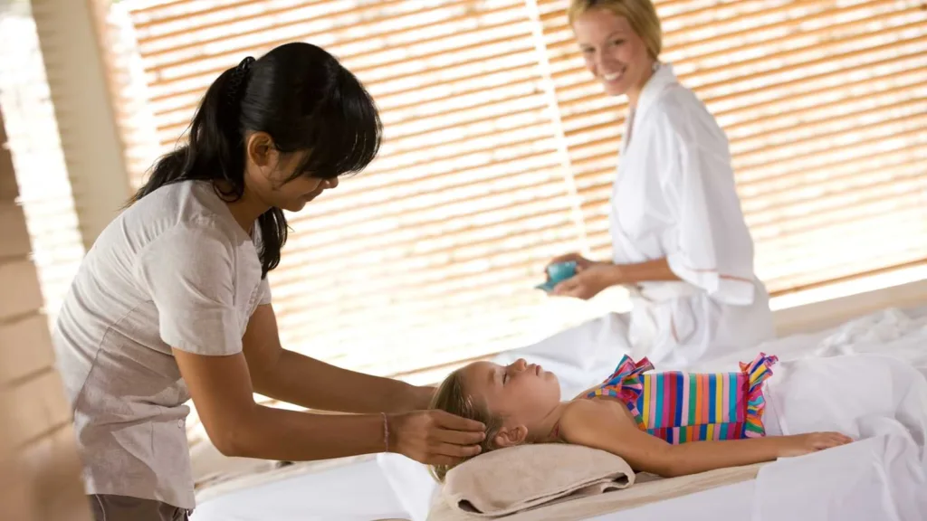 A little girl receiving head massage spa treatment - Bali map for kids