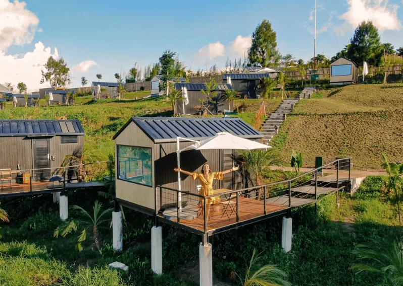 An aerial view of a cabin amidst lush greenery compound