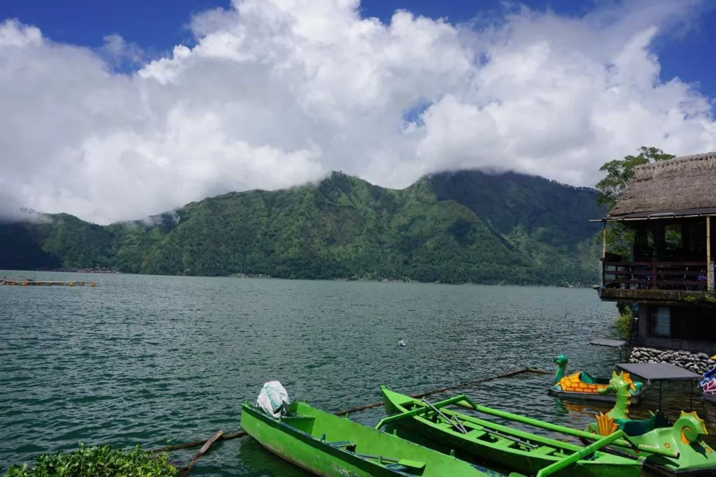 A view of Lake Batur with some boats at the edge of it