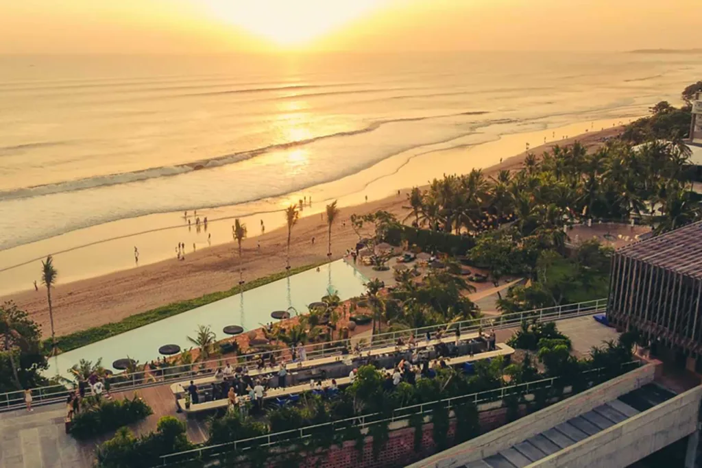 Aerial view of Potato Head Beach Club, one of the best bars in Bali, at sunset with a pool and dining area in the foreground