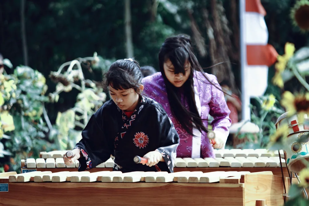 bermain alat musik tradisional di tempat wisata di likupang