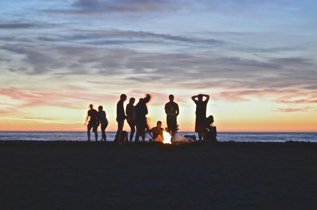 menyalakan api unggun atau bonfire di pinggir pantai