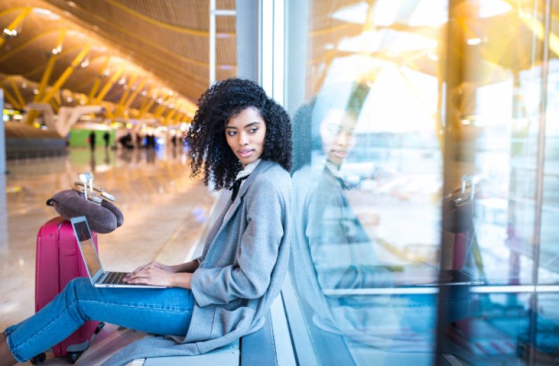 black-woman-working-with-laptop-airport-waiting-window_153437-8