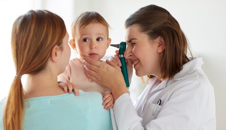 Anak sedang diperiksa telinganya oleh dokter